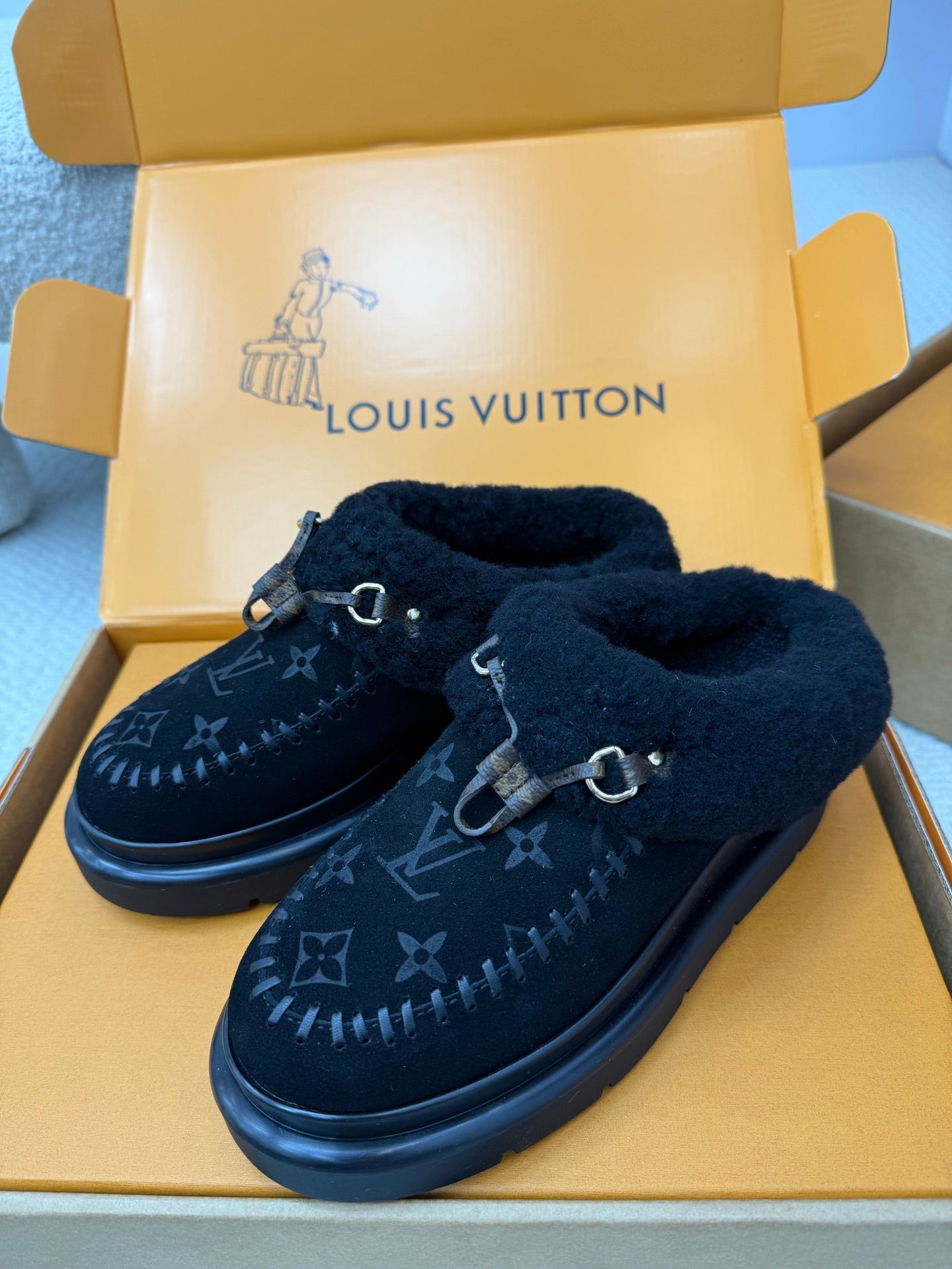 Ladies slip-on shoes with plush tongue, dark monogram logo, buckle strap, thick rubber sole