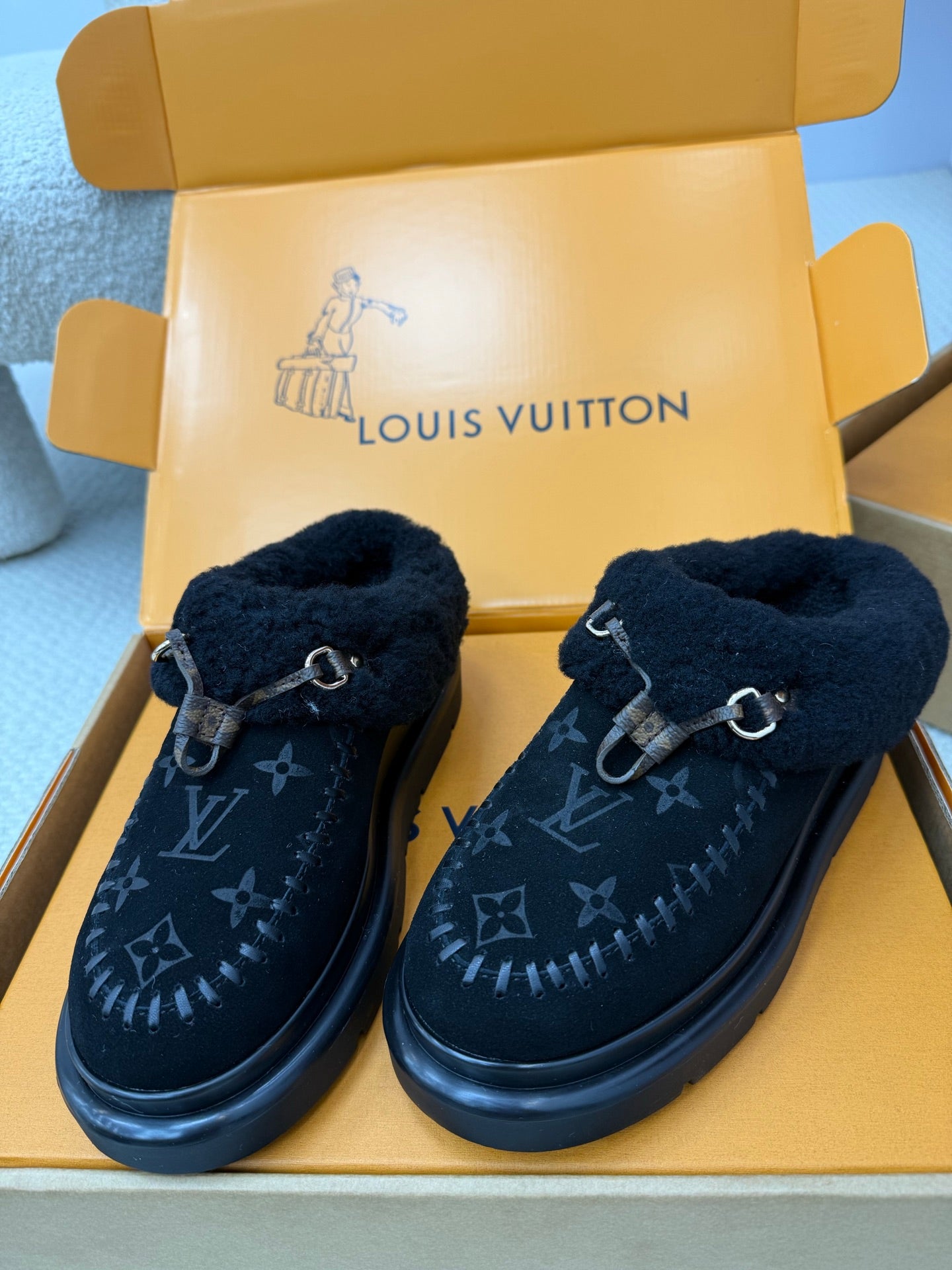 Pair of ladies slip-on shoes with plush lining and buckle, dark monogram upper, rubber sole