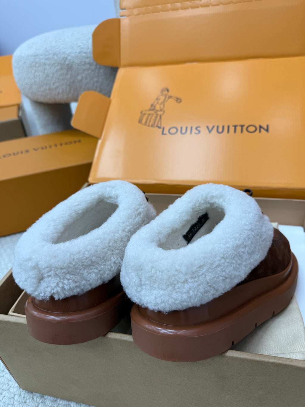 Louis Vuitton shearling clogs, light blue loop straps over brown monogram uppers