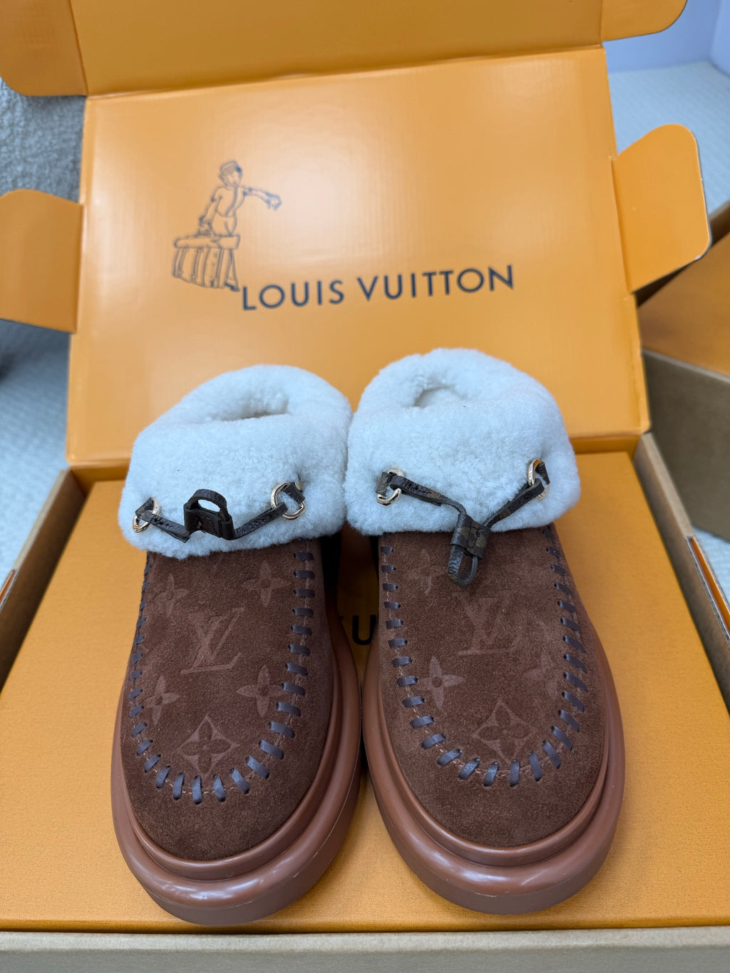 Louis Vuitton shearling mules, brown monogram uppers, light blue fuzzy straps