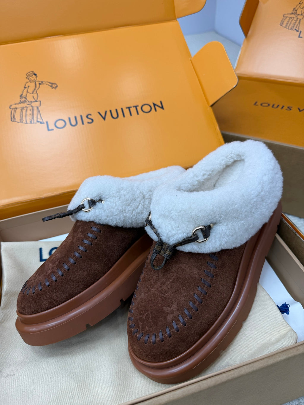 Louis Vuitton shearling mules, brown monogram uppers with light blue fuzzy straps