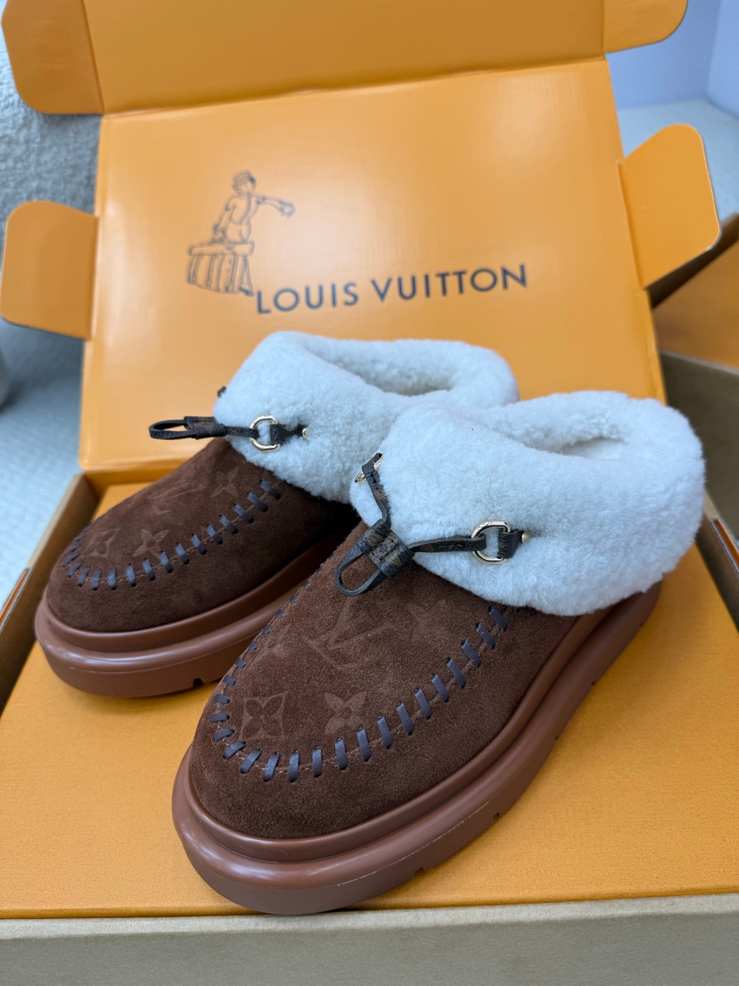 Louis Vuitton shearling mules, pair with brown monogram uppers and light blue fur lining