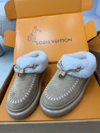 Pair of grey slip-on sneakers with light blue shearling cuffs and side seam stitching