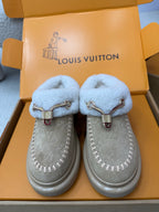 Pair of light blue shearling slip-on sneakers with grey suede uppers and side stitching