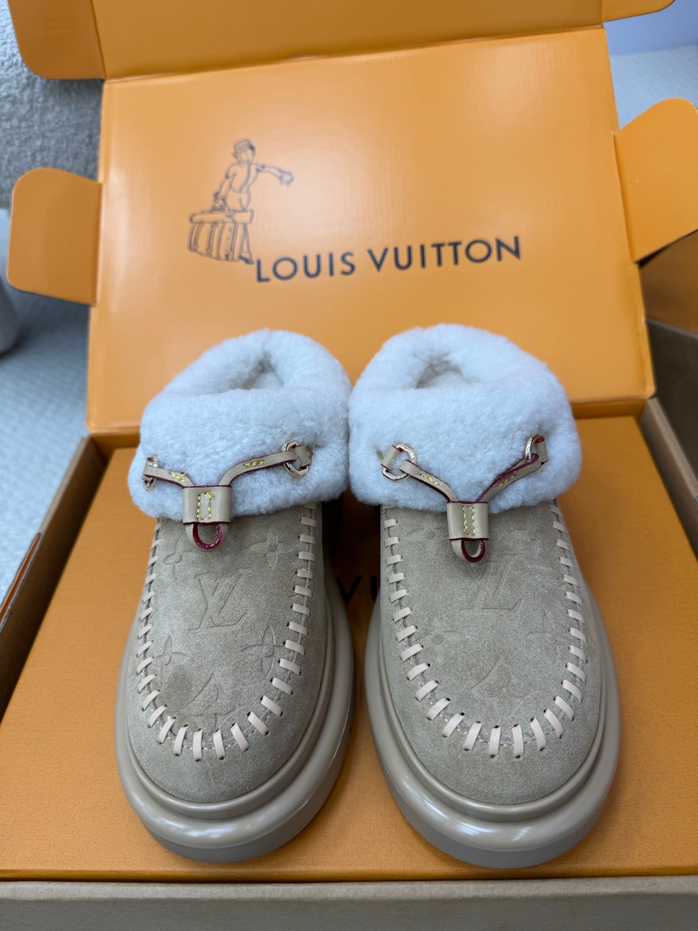 Pair of light blue shearling slip-on sneakers with grey suede uppers and side stitching