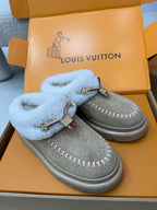 Grey slip-on sneakers with light blue shearling cuffs and buckle strap details