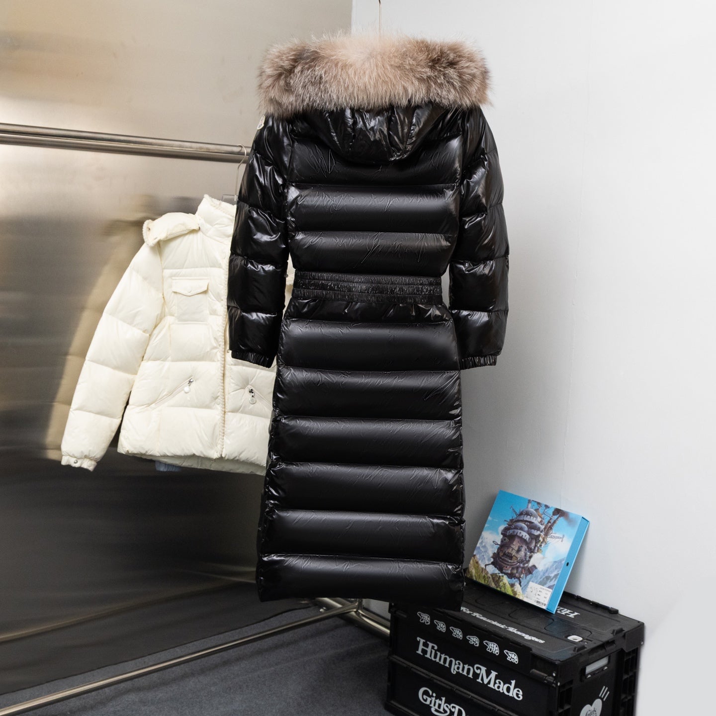 Moncler long puffer coat in black, with faux-fur hood and horizontal quilted panels