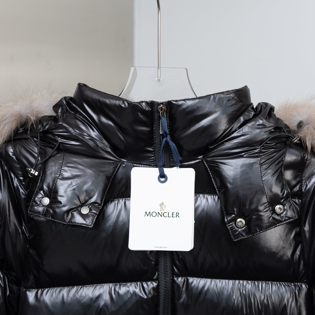 Moncler black puffer coat with fur hood, snap pockets, and hanging price tag