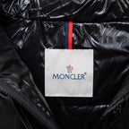 Moncler logo patch on black puffer jacket collar, with blue-red stripe trim