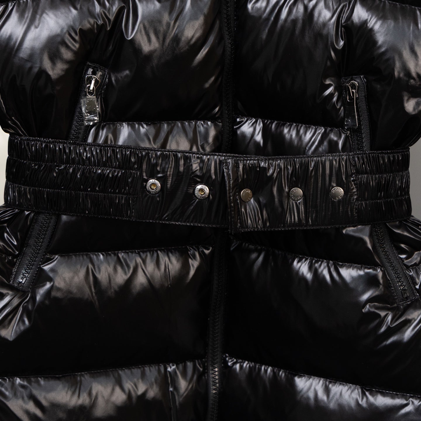 Moncler black puffer coat with belt, snap buttons, and front zipper placket