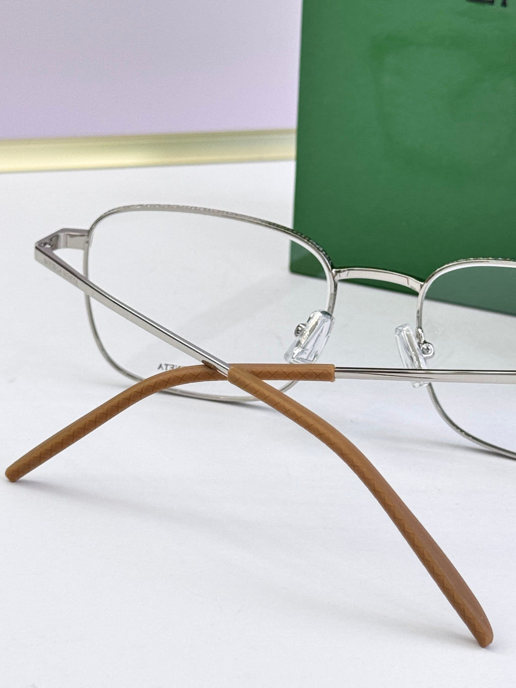 Silver eyeglass frames with clear lenses and light brown temple tips