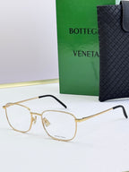 Gold eyeglass frames with clear lenses and dark blue temples