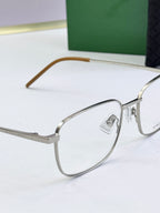 Silver eyeglass frames with clear lenses and light brown arms