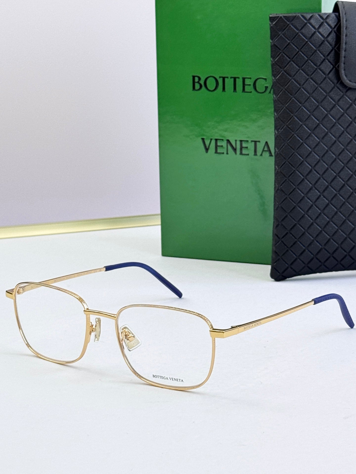 Gold eyeglass frames with clear lenses and navy blue temples