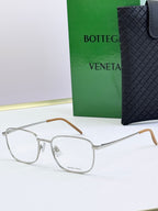 Silver eyeglass frames with clear lenses and light brown temples