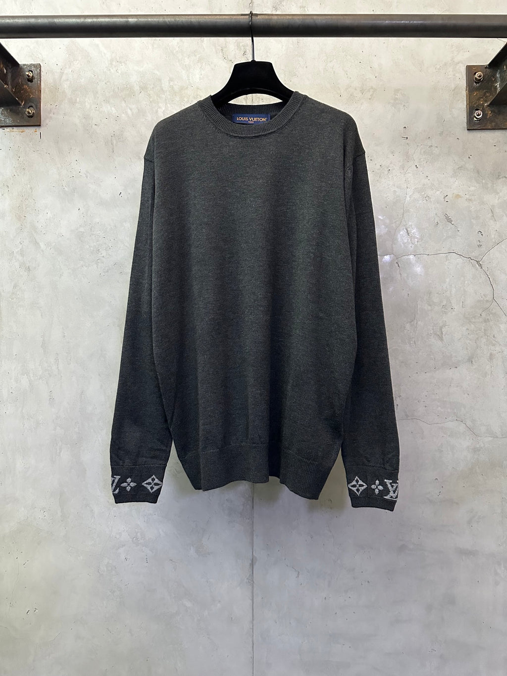 Dark gray long-sleeve crewneck sweater with logo cuff trim and patterned hems