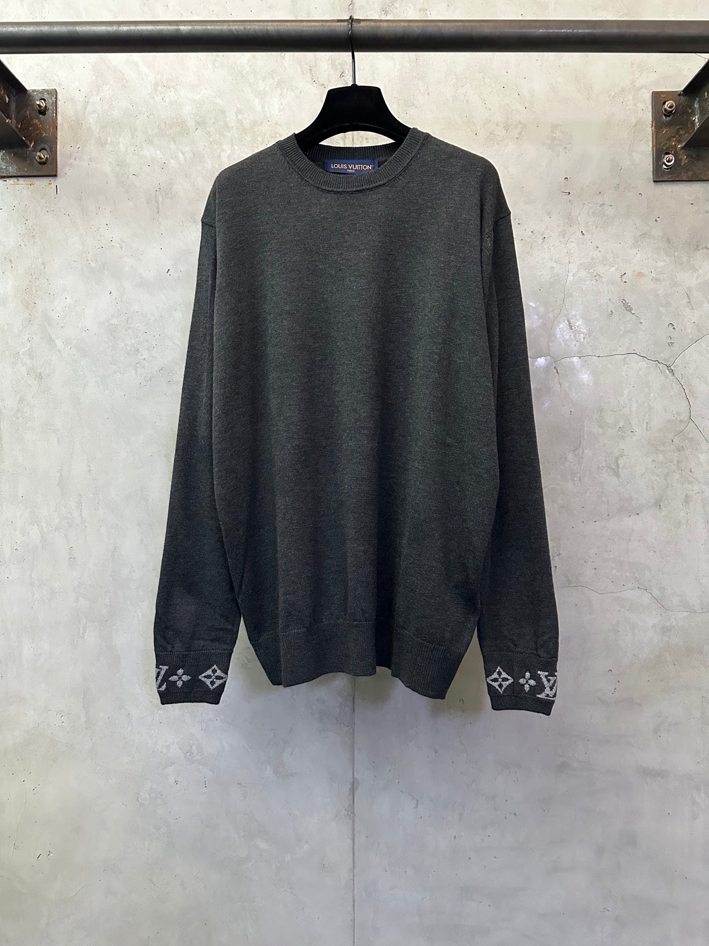 Dark gray long-sleeve crewneck sweater with logo cuff trim and patterned hems