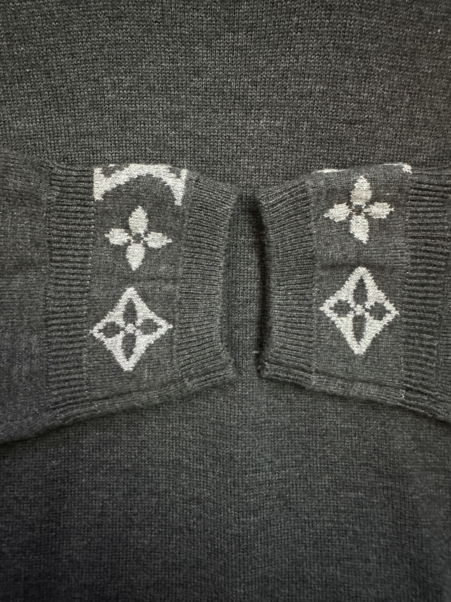 Dark gray sweater cuffs with white geometric logo knit trim