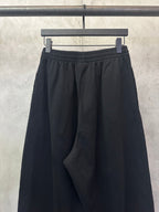 Balenciaga black wide-leg pants, gathered front, elastic waistband, frayed hem