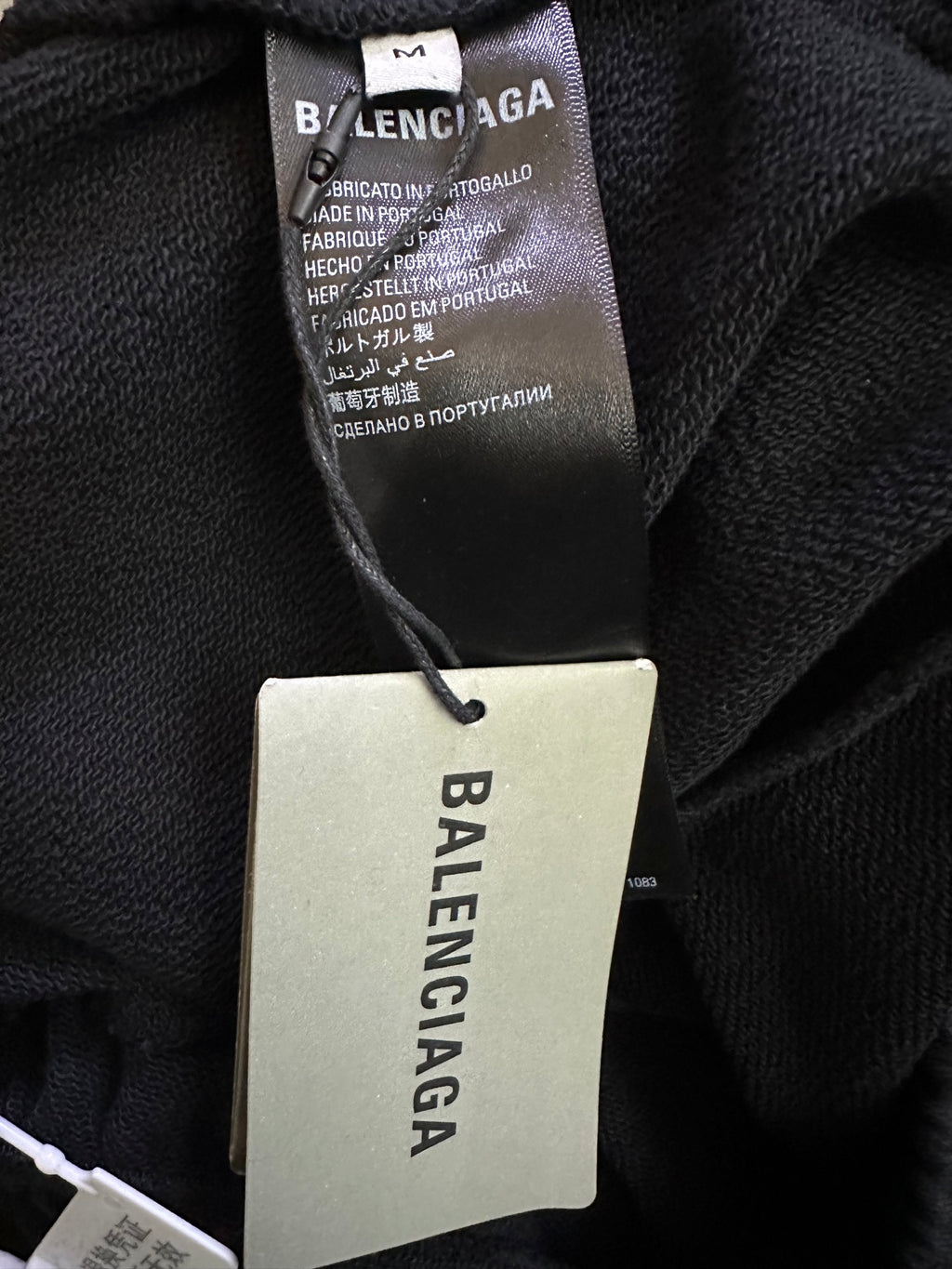 Balenciaga clothing tag and care label on dark fabric
