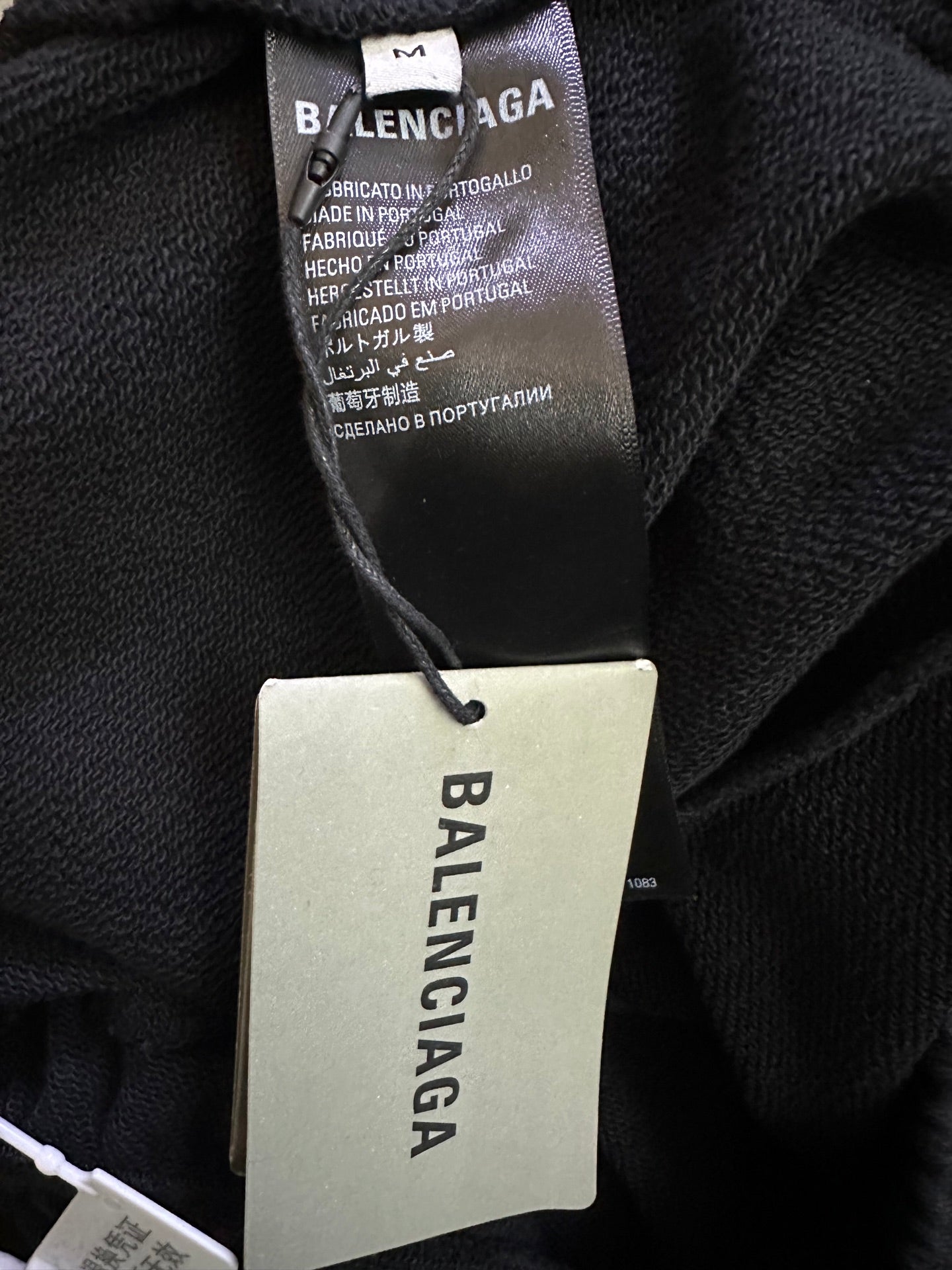 Balenciaga clothing tag and care label on dark fabric