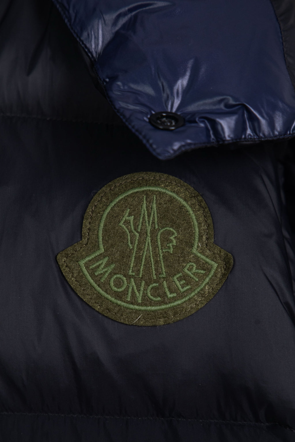 Moncler long puffer jacket chest patch logo in green on dark navy fabric