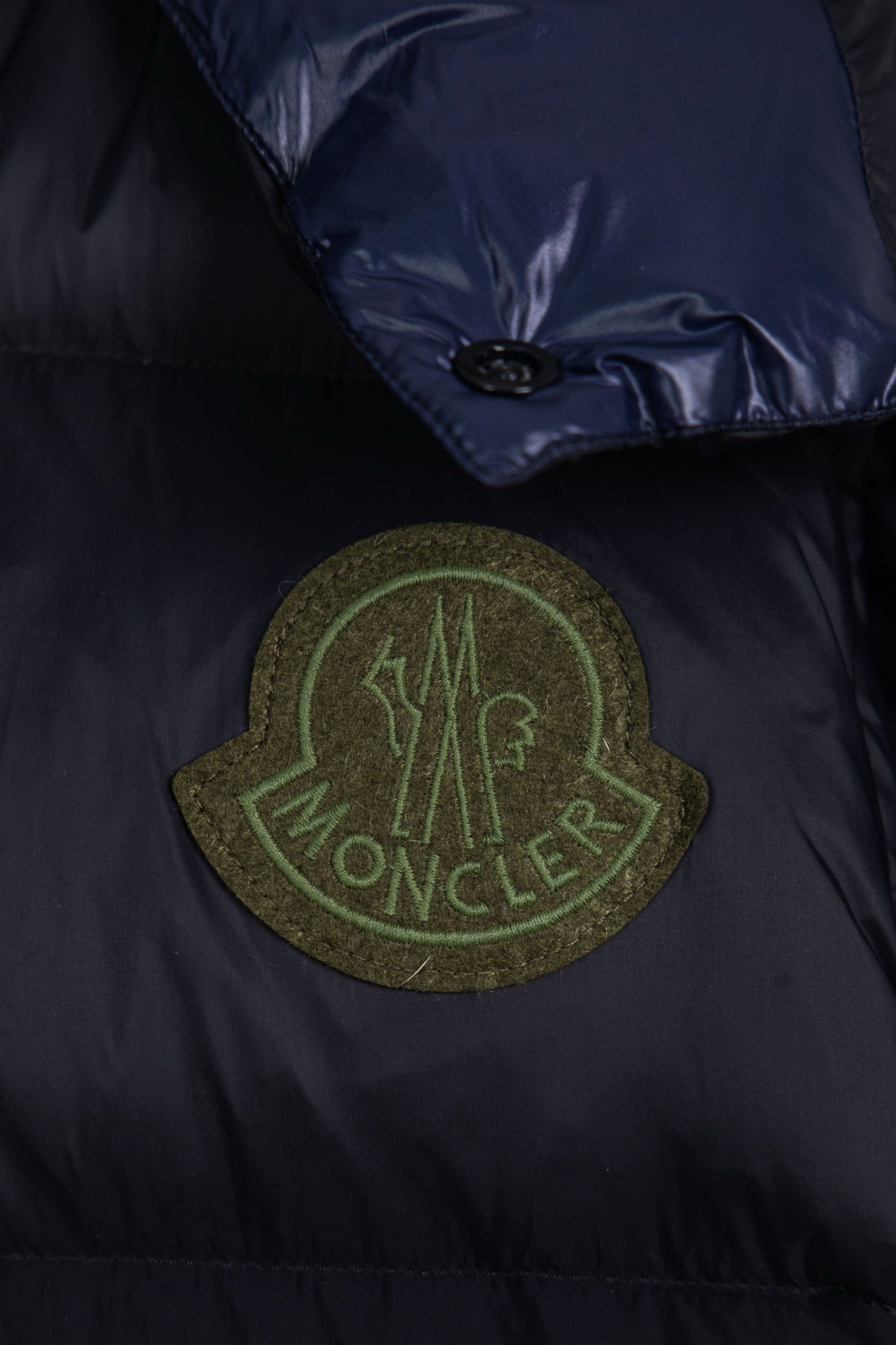 Moncler long puffer jacket chest patch logo in green on dark navy fabric
