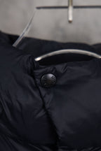 Moncler long puffer jacket neck area with embossed button and dark navy fabric