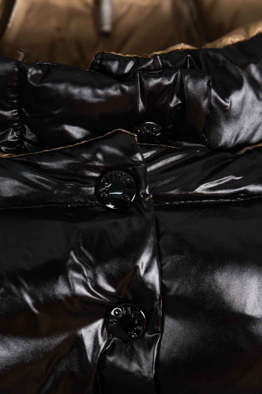Moncler long puffer jacket close-up of front buttons and quilting, black