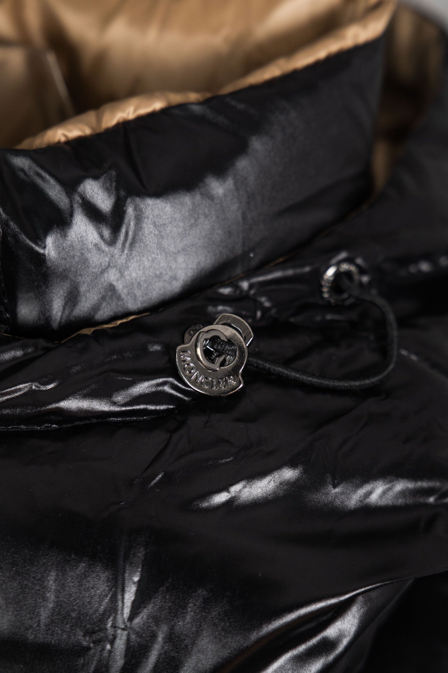 Moncler long puffer jacket close-up of snap button and cord, black