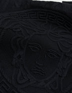 Versace black knit sweater front with large raised Medusa-style emblem pattern