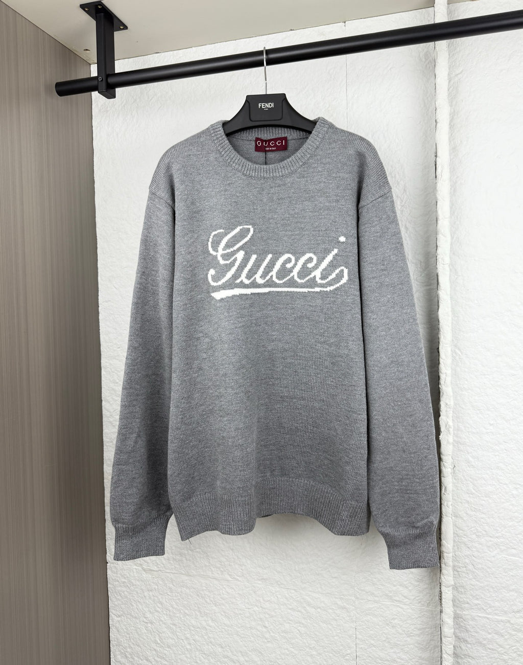 Gucci knit sweater with white script logo on gray crewneck