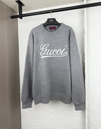 Gucci knit sweater with white script logo on gray crewneck