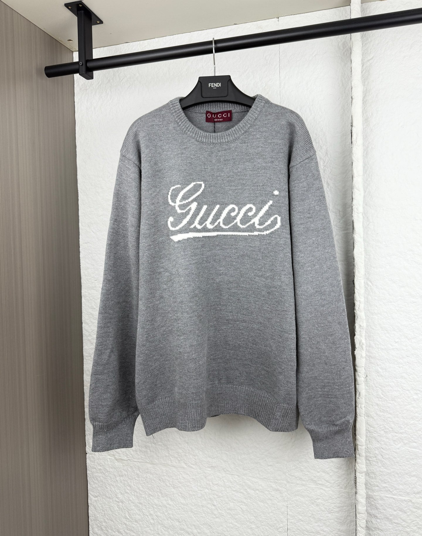 Gucci knit sweater with white script logo on gray crewneck