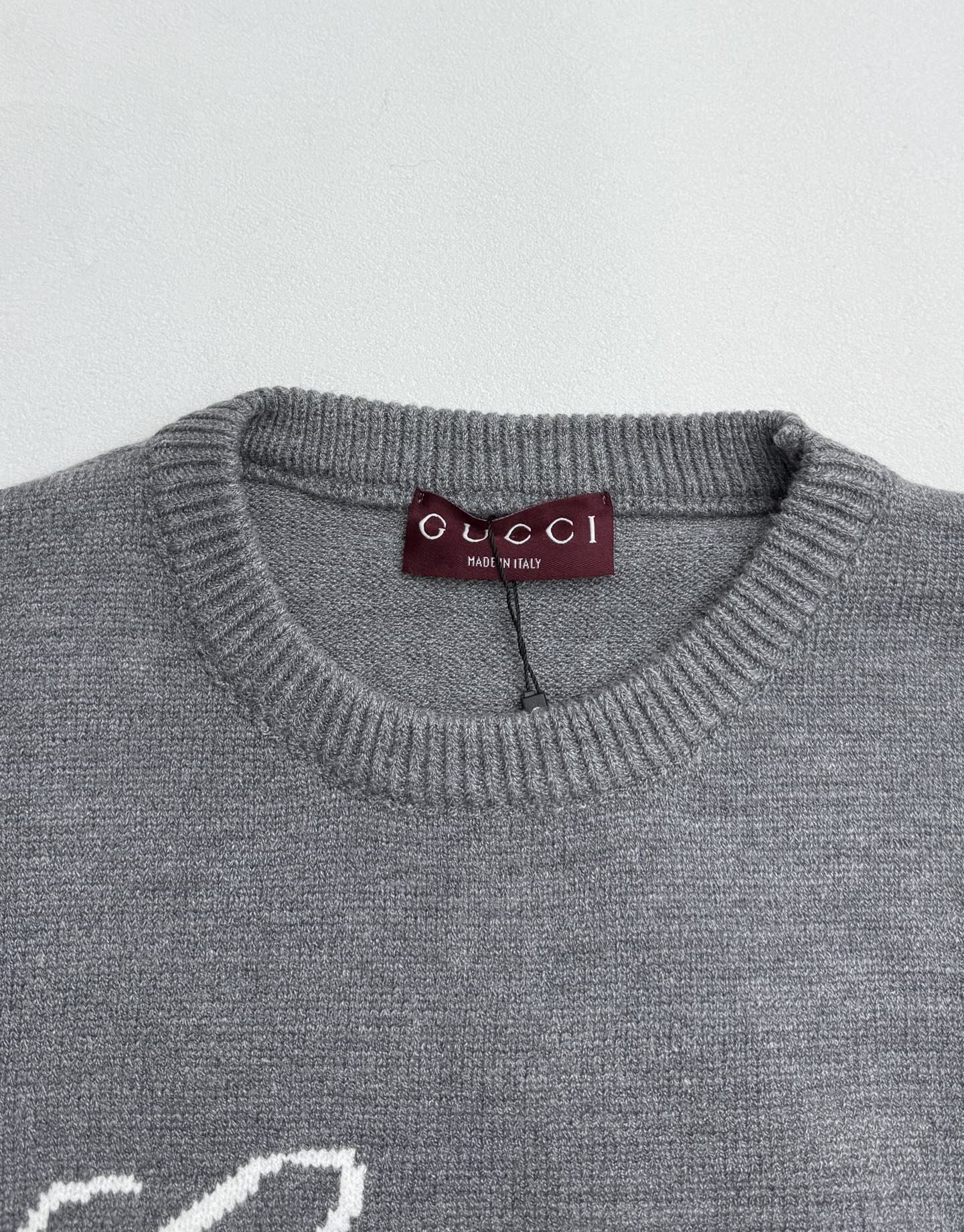 Gucci knit sweater collar with purple Gucci label on gray crewneck