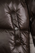 Long puffer jacket upper front with round snap button on dark brown quilting