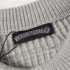 Light gray ribbed knit cardigan with woven brand label at the collar