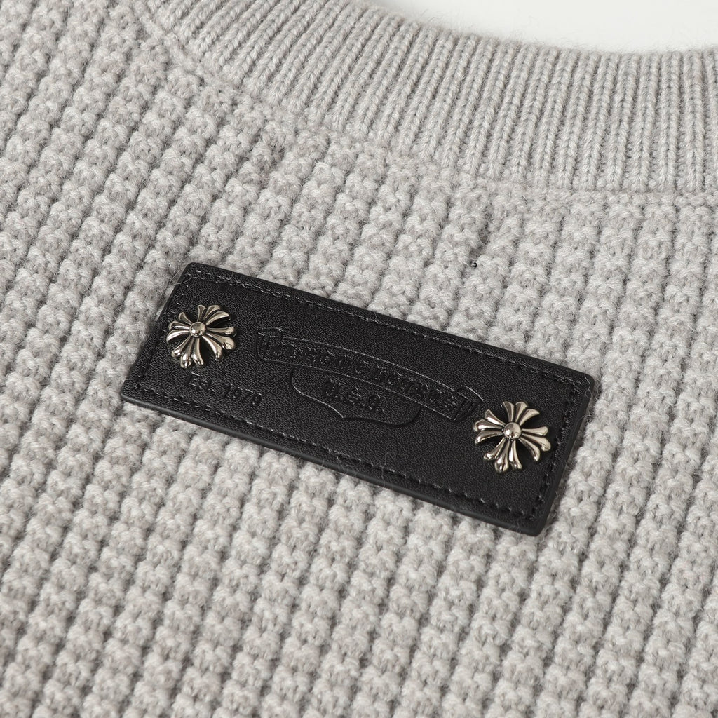Light gray knit fabric with dark leather brand label and decorative studs