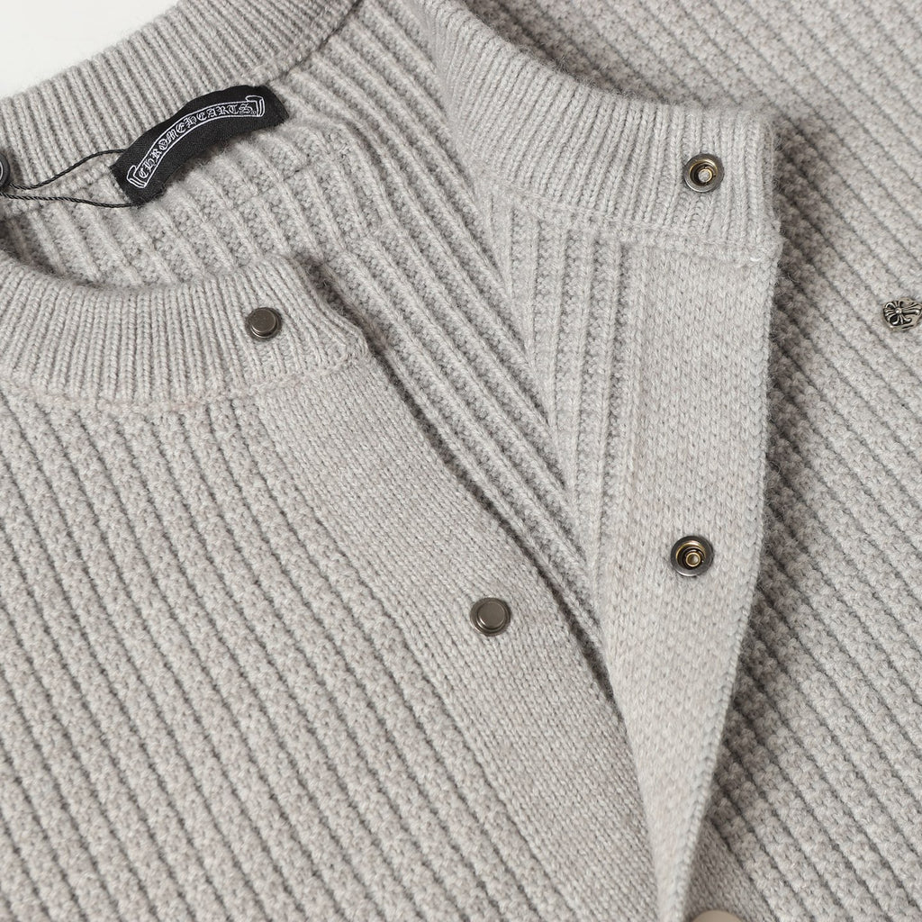 Light gray knit cardigan front with metal buttons and braided trim detail