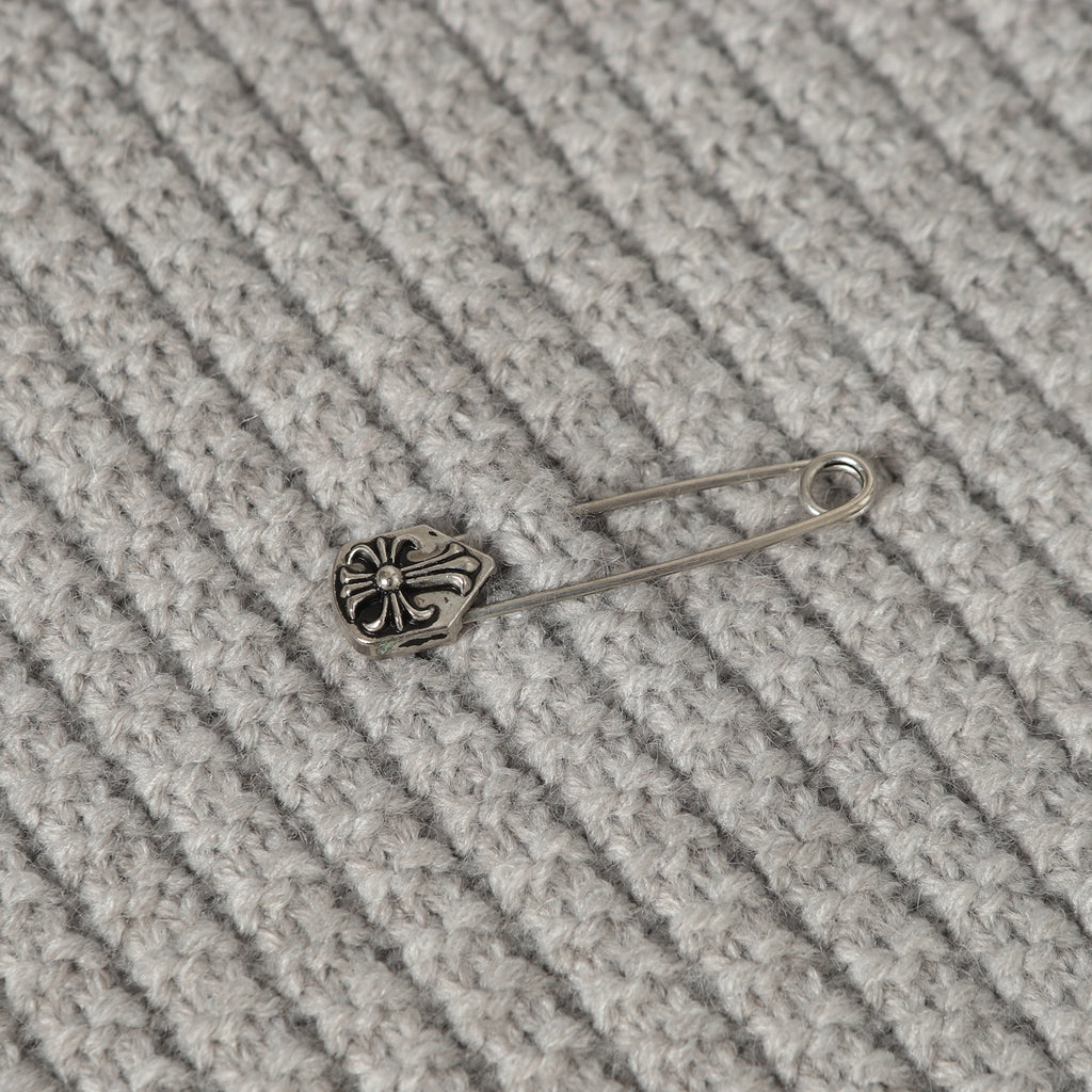 Light gray knit fabric with small metal pin ornament on ribbed texture