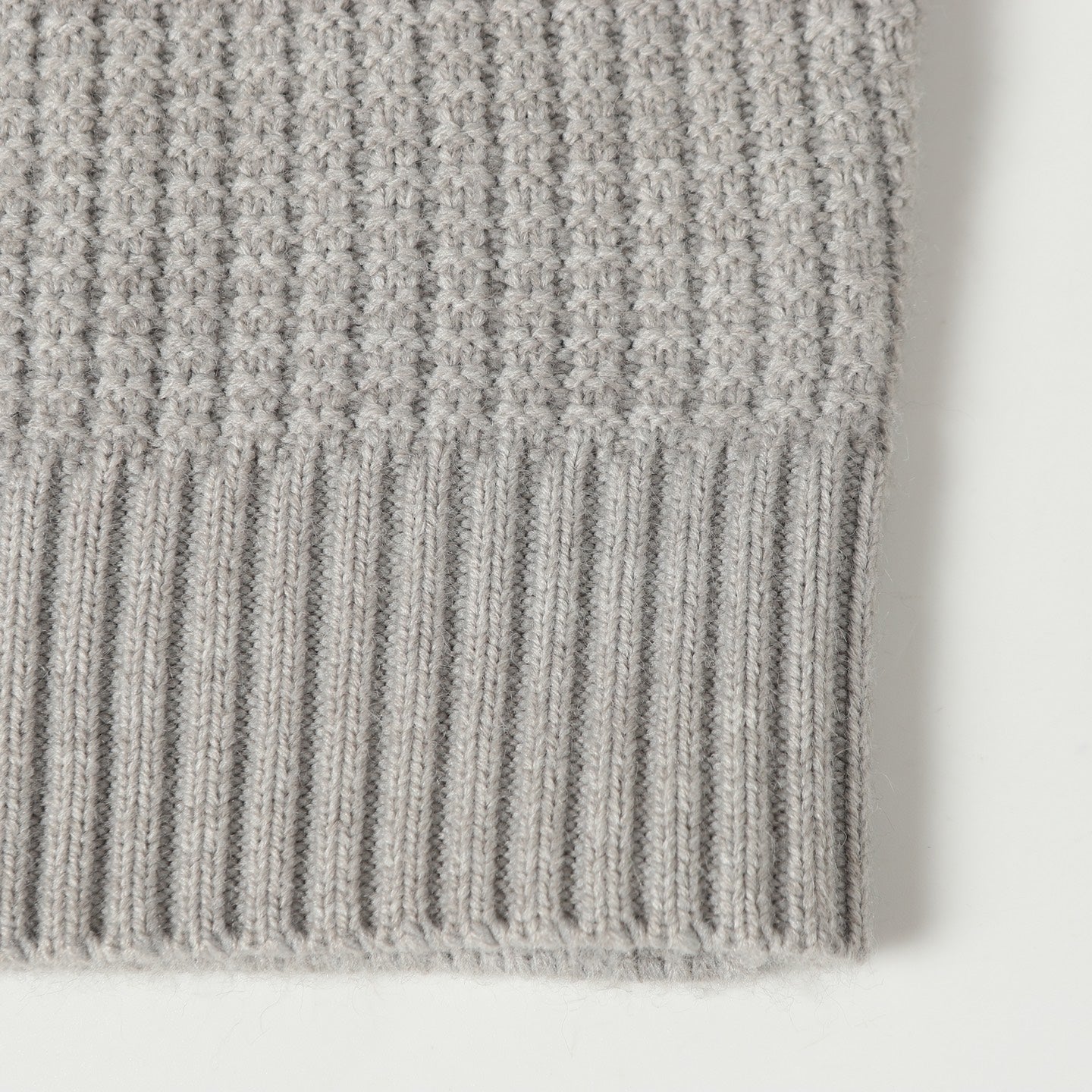 Light gray knit cardigan hem with ribbed texture