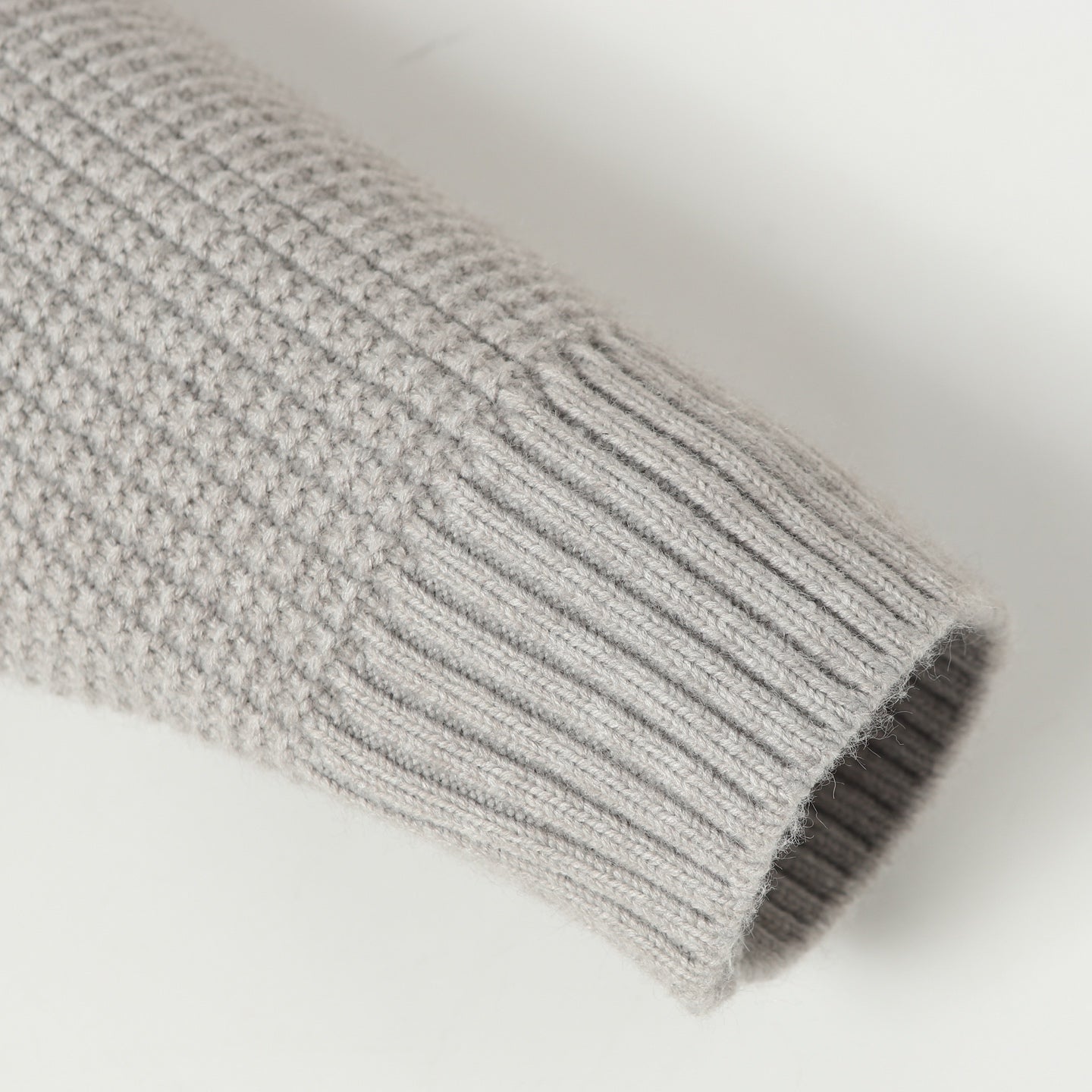 Light gray ribbed knit sleeve cuff with rolled hem