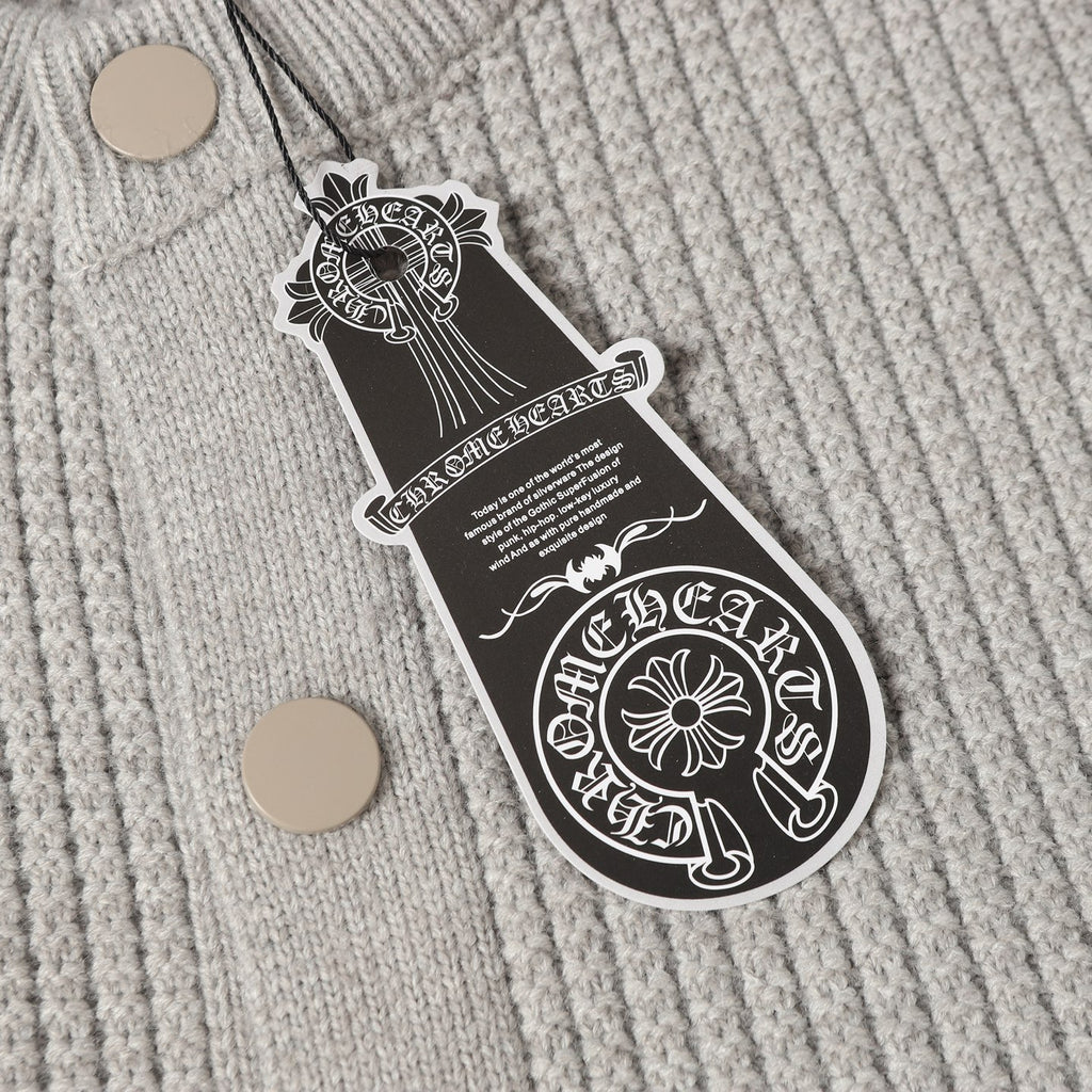 Light gray knit cardigan close-up with round buttons and hanging brand tag