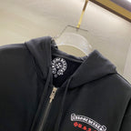 Dark hoodie close-up showing hood lining, front zipper, and chest logo patch