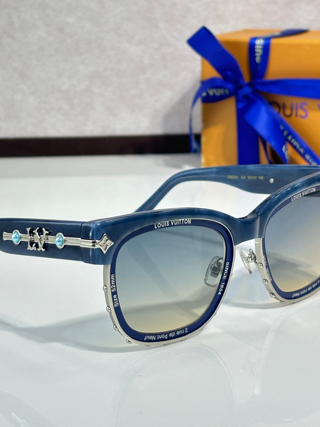 Louis Vuitton sunglasses, round blue-tinted lenses with blue frame and gold logo bar