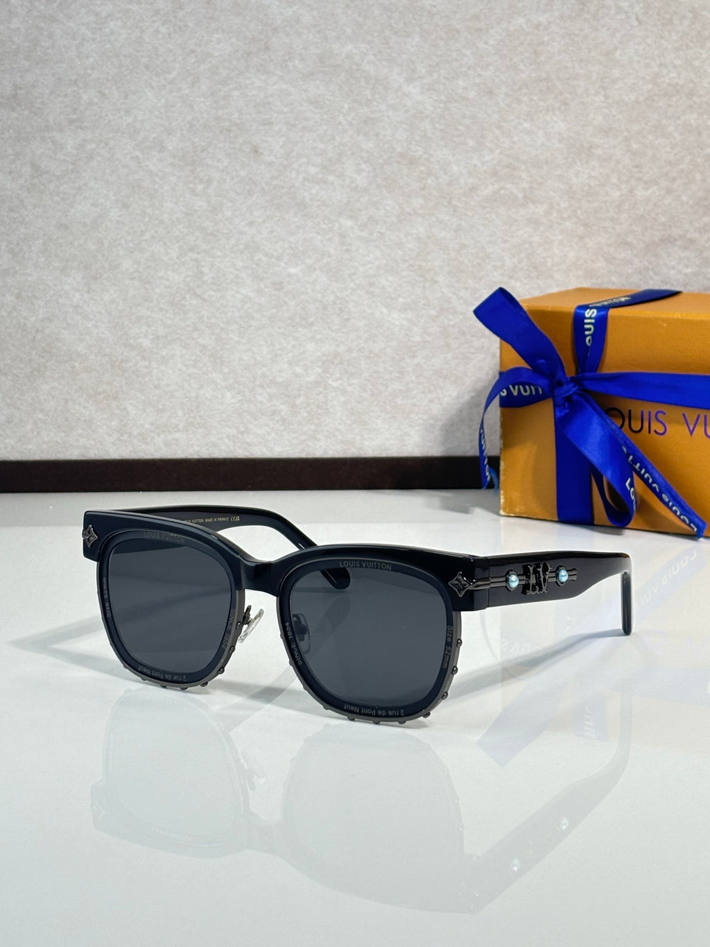 Louis Vuitton sunglasses, glossy black frame with dark lenses and gold-tone accents