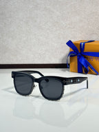 Louis Vuitton sunglasses, glossy black frame with dark lenses and gold-tone accents
