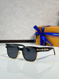 Louis Vuitton sunglasses, black frame with gold emblem and dark lenses