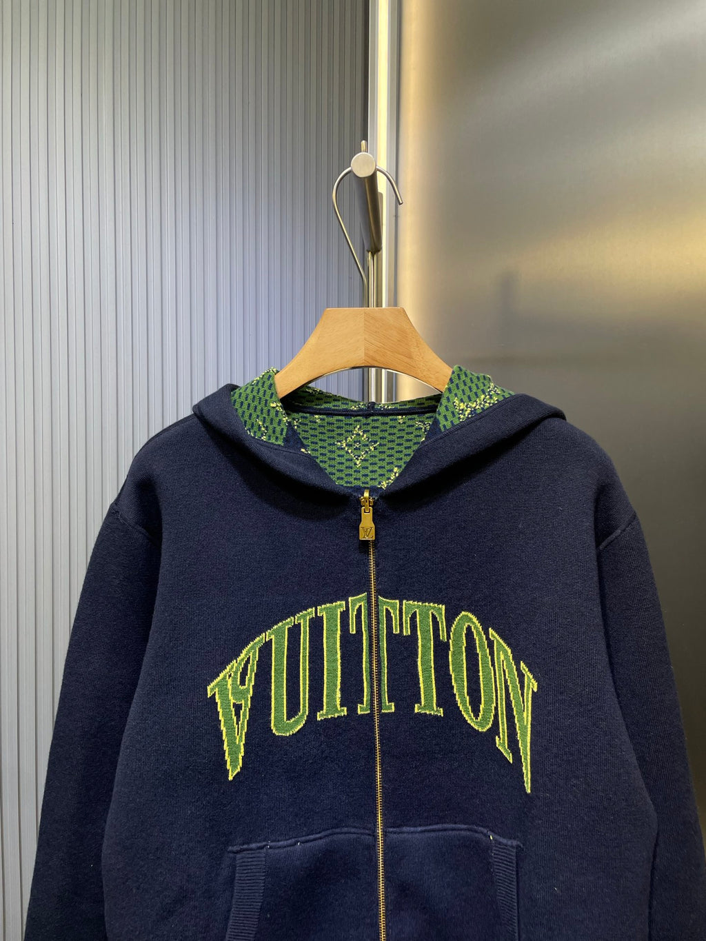 Navy Louis Vuitton zip-up hoodie with green logo print and patterned hood lining.