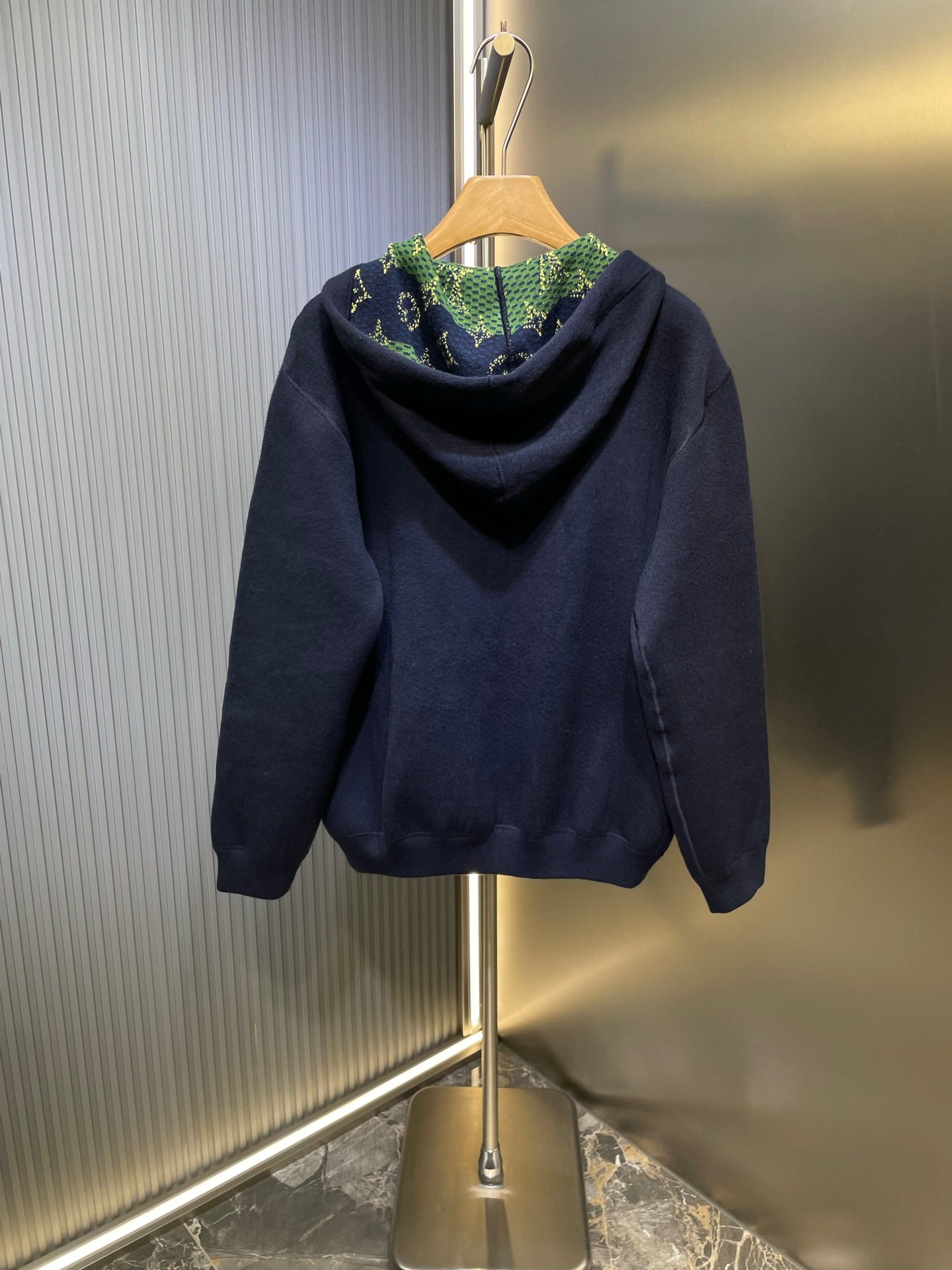 Navy zip-up hoodie with hood, back drape, and no visible front logo.